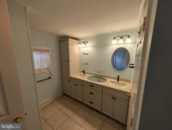 a bathroom with a double vanity sink and mirror