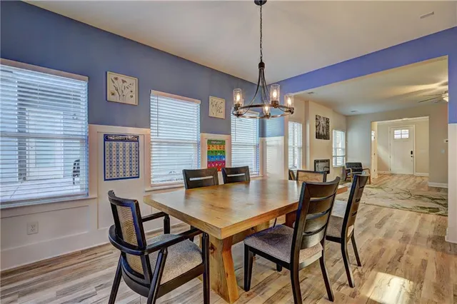 a kitchen with stainless steel appliances kitchen island granite countertop a table chairs stove and refrigerator