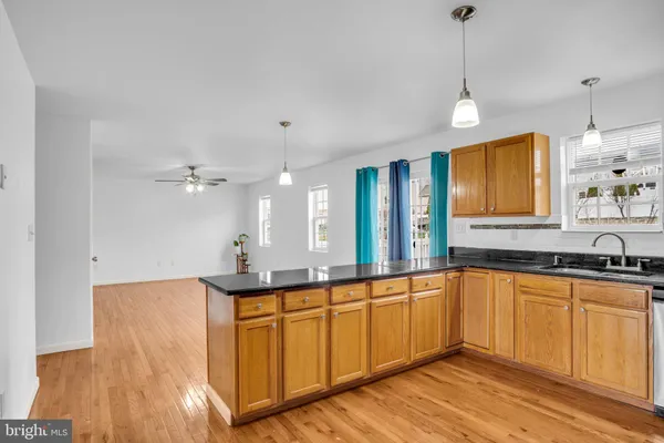 a view of a kitchen with microwave and wooden floor