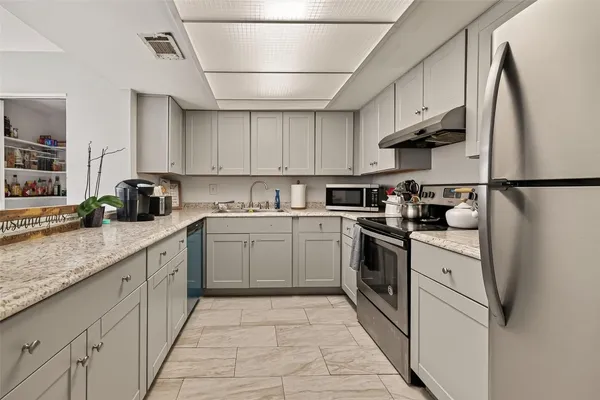 a kitchen with white cabinets stainless steel appliances and a sink