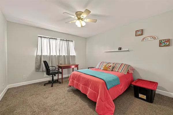 a bedroom with a bed chair and a window