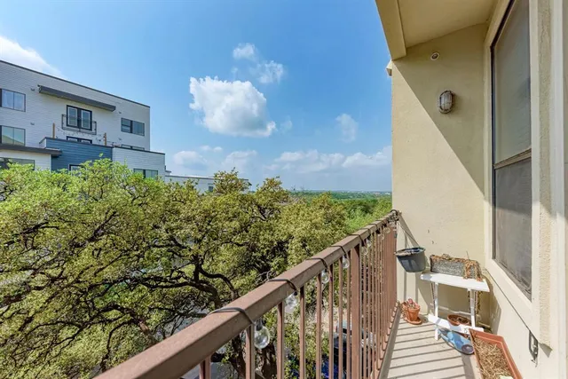 a view of a balcony with wooden floor and fence