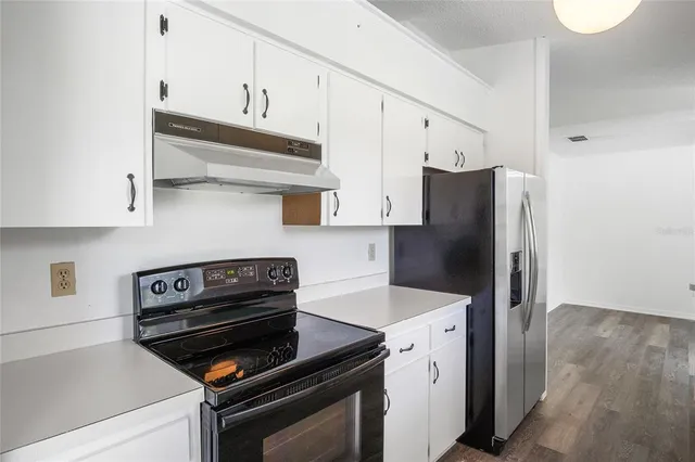 a kitchen with a refrigerator stove and cabinets
