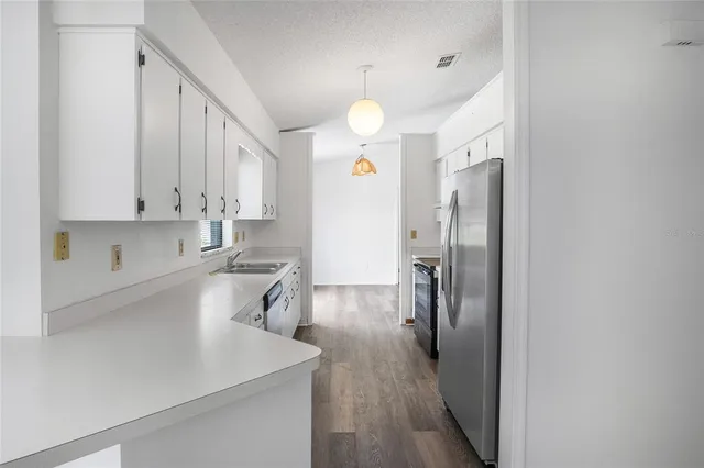 a kitchen with stainless steel appliances granite countertop a sink a stove and a refrigerator