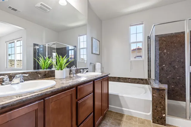 a bathroom with a granite countertop sink mirror and a bathtub