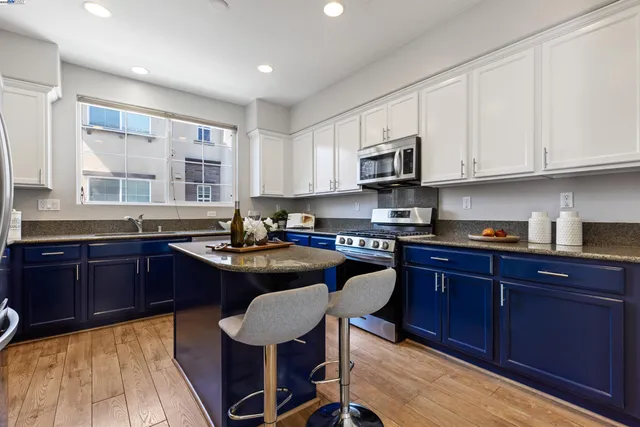 a kitchen with granite countertop a sink stove and cabinets