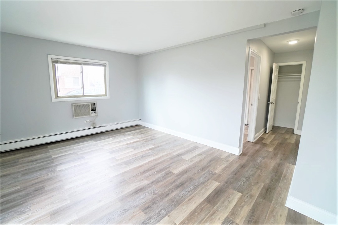 1100 North Wheeling Road, Unit 1B Mount Prospect, IL 60056 - Photo 4 of 11 an empty room with wooden floor and windows