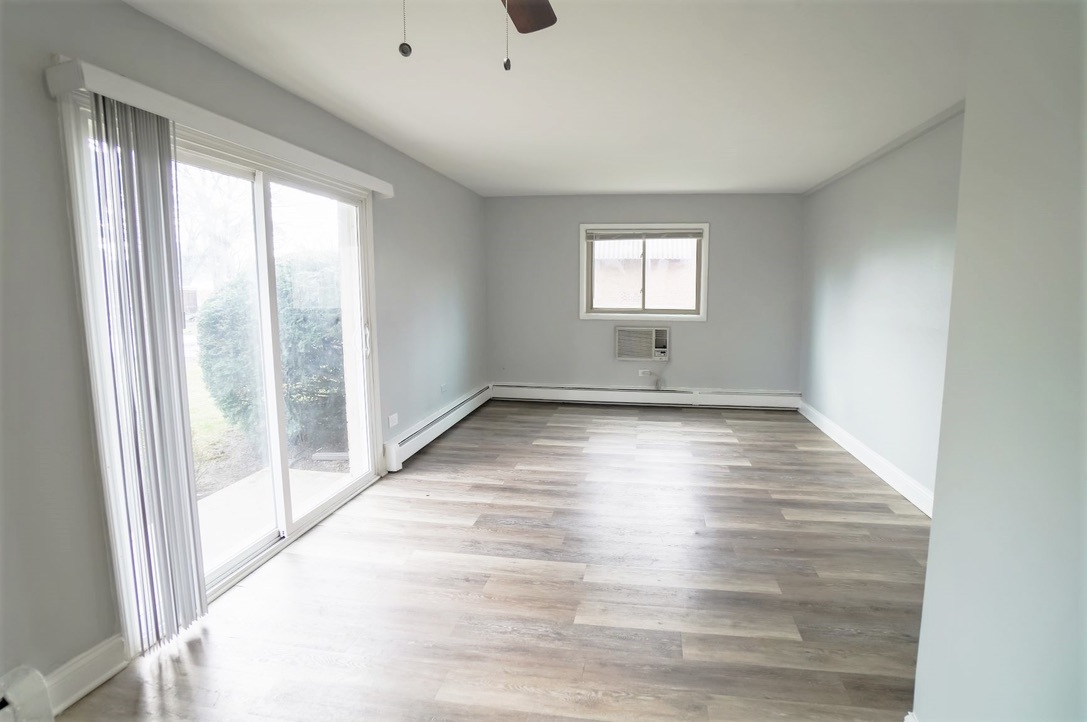 1100 North Wheeling Road, Unit 1B Mount Prospect, IL 60056 - Photo 5 of 11 a view of an empty room with wooden floor and a window