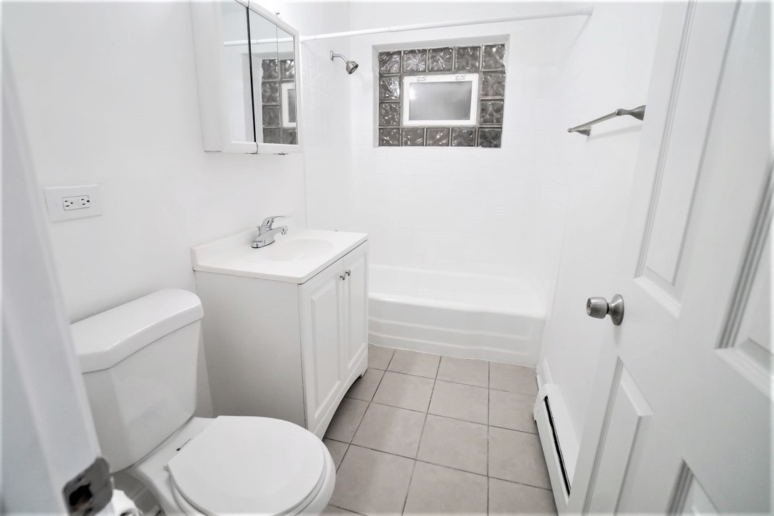 1100 North Wheeling Road, Unit 1B Mount Prospect, IL 60056 - Photo 6 of 11 a white toilet sitting next to a bathroom sink