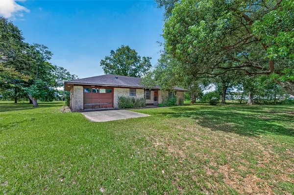 a front view of a house with yard tree and green space