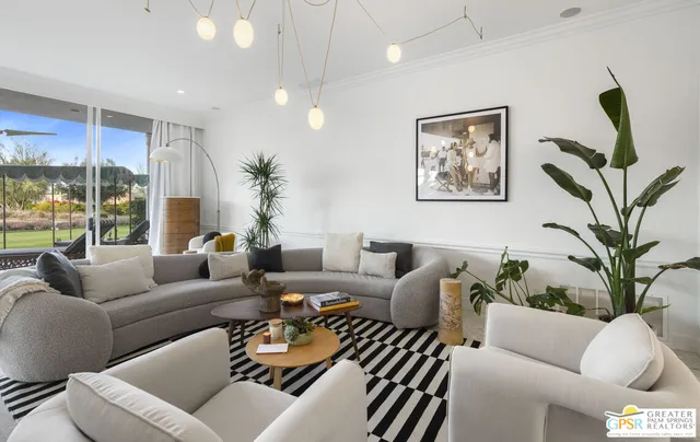 a living room with furniture ceiling fan and a large window