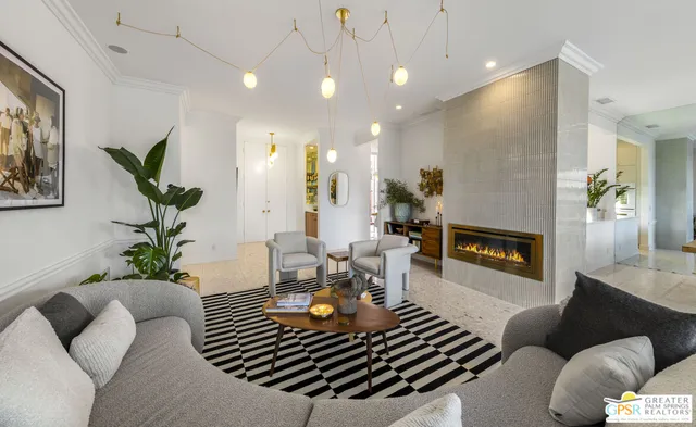 a living room with furniture a fireplace and a potted plant