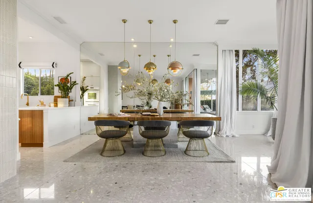 a room with lots of white furniture and a large window