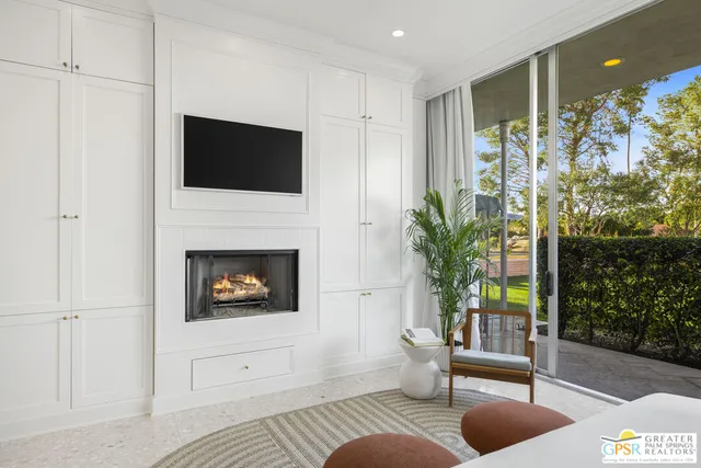 a living room with furniture a flat screen tv and a fireplace