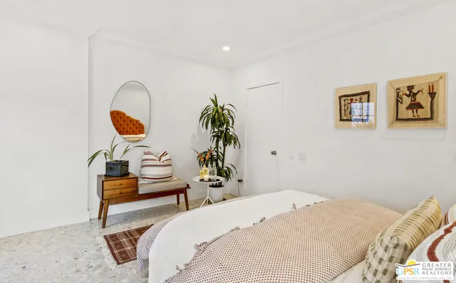 a bedroom with bed and a painting on the wall