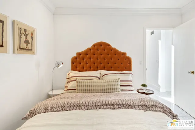 a bedroom with a bed and a painting on the wall