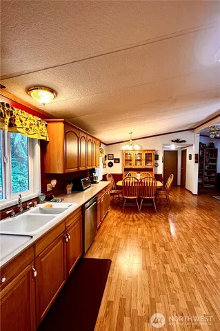 a large dining hall with stainless steel appliances granite countertop a sink and wooden cabinets