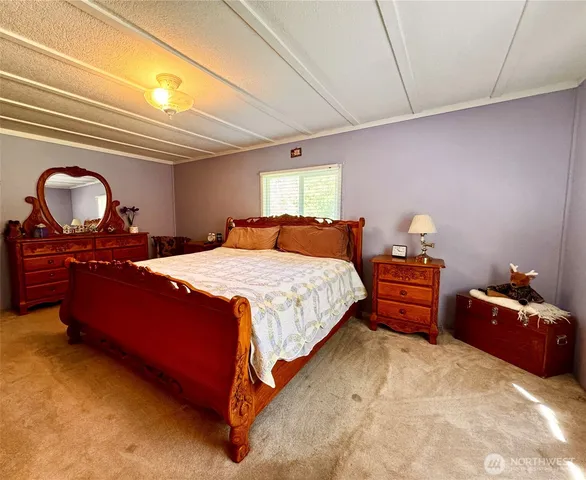 a bedroom with a bed and dresser with mirror