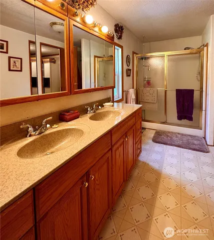 a spacious bathroom with a sink double vanity granite and a mirror