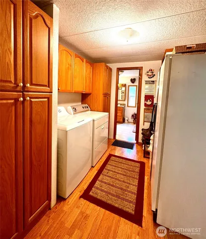 a view of a hallway with wooden floor and electronic appliances