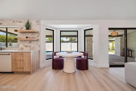 a living room with furniture a large window and wooden floor