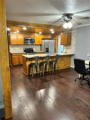 a kitchen with stainless steel appliances a dining table chairs stove and granite counter top