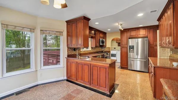 a kitchen with stainless steel appliances granite countertop a refrigerator and a stove top oven