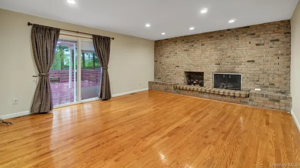 a view of an empty room with a fireplace and a window