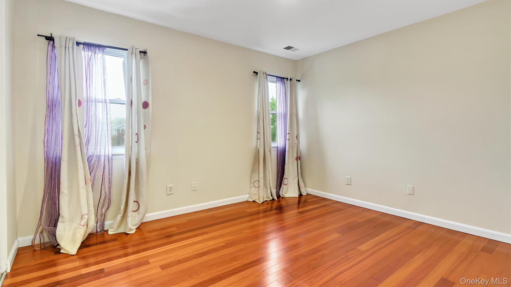 47 Carriage Road Roslyn, NY 11576 - Photo 22 of 31 Spare room featuring light wood finished floors, baseboards, and visible vents