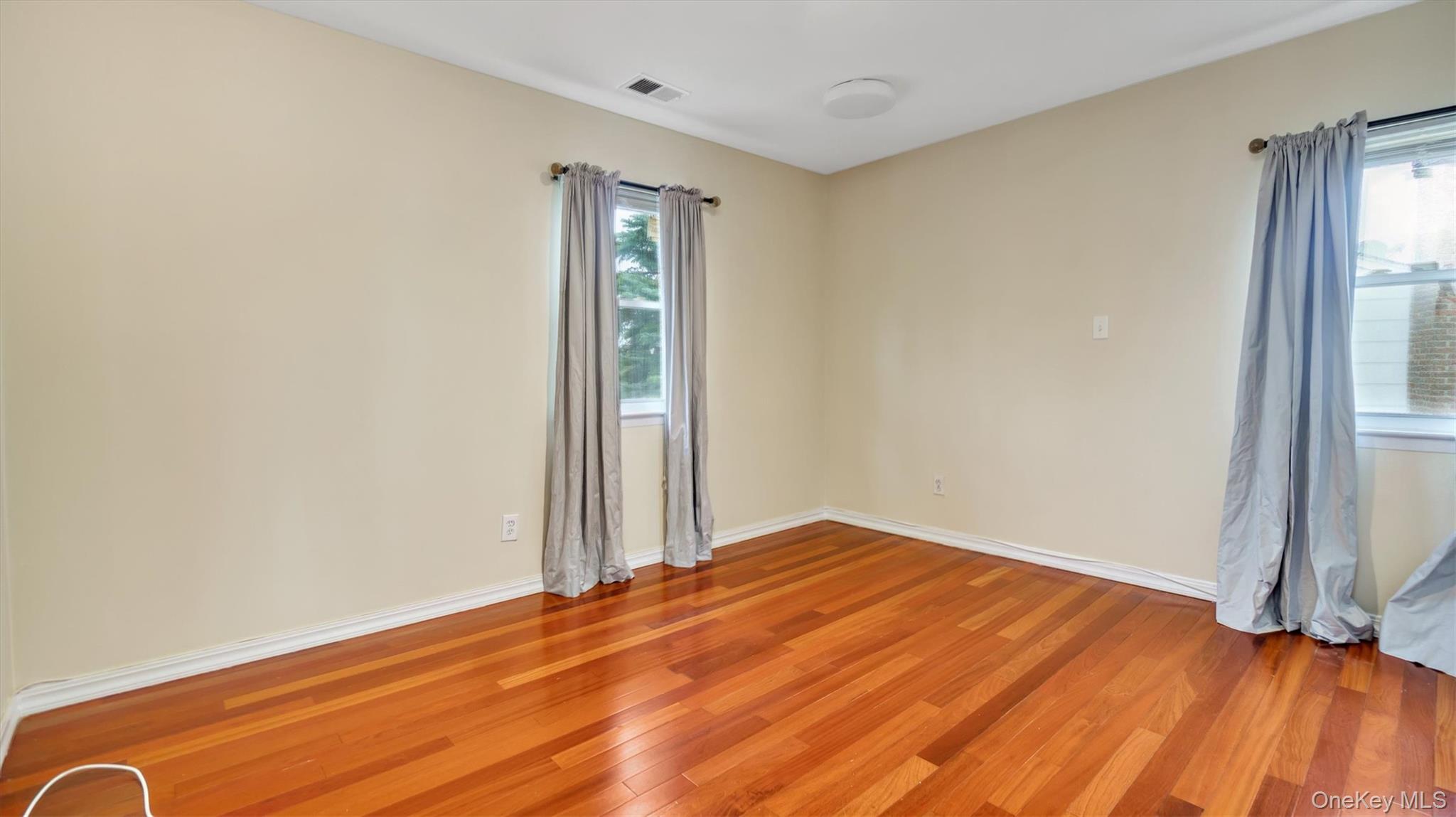 47 Carriage Road Roslyn, NY 11576 - Photo 25 of 31 Unfurnished room with light wood-style flooring, baseboards, and visible vents