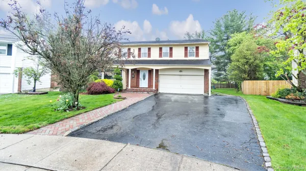 a front view of a house with a yard and a garage