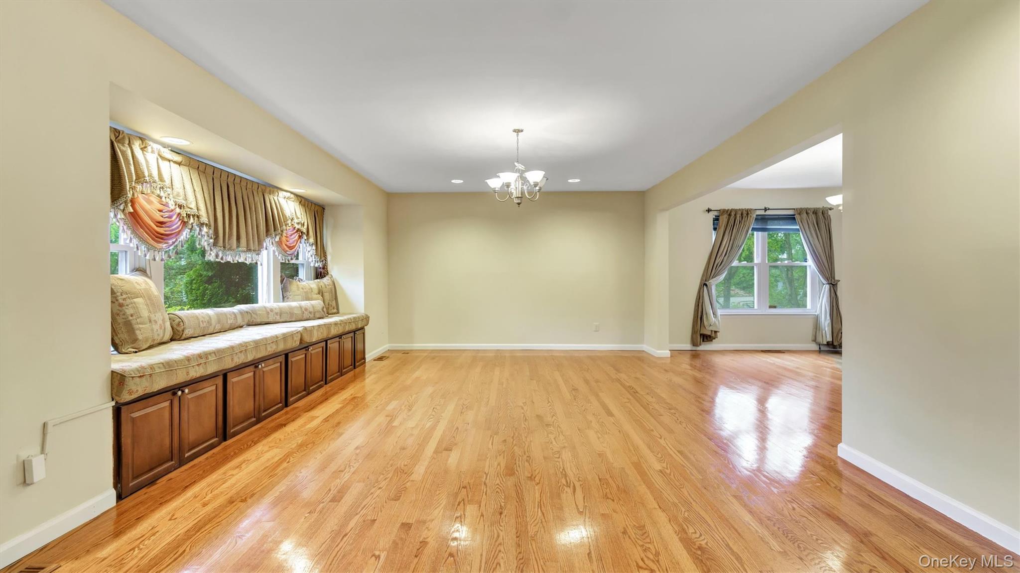47 Carriage Road Roslyn, NY 11576 - Photo 6 of 31 Unfurnished living room featuring light wood finished floors, a chandelier, baseboards, and recessed lighting