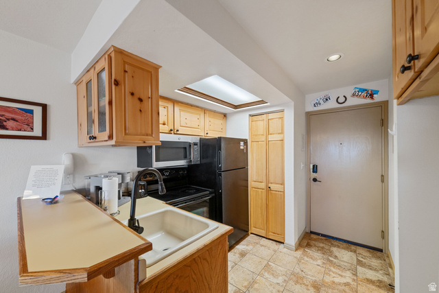 150 Ridgeview Street, Unit 117 Brian Head, UT 84719 - Photo 12 of 20 Kitchen featuring range with electric cooktop, light wood finish cabinetry, stainless steel microwave, light countertops, and glass fronted cabinets