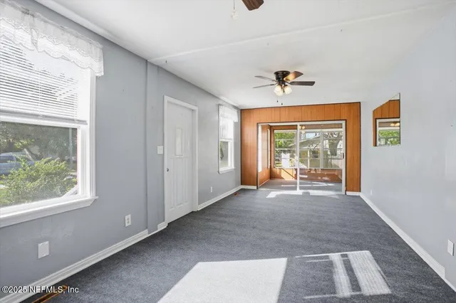 a big room with windows and a ceiling fan