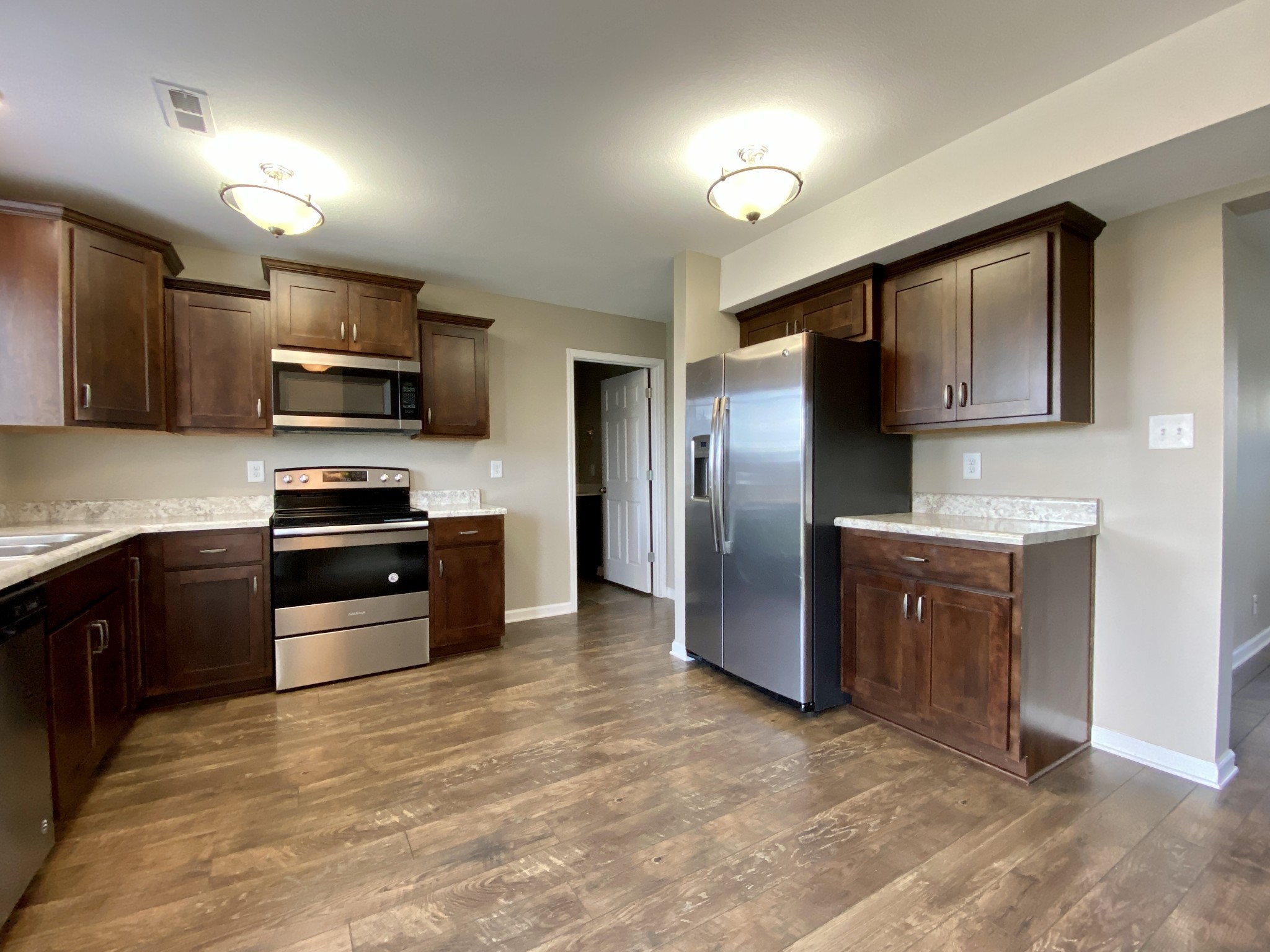 951 Hugh Hunter Road Oak Grove, KY 42262 - Photo 12 of 35 a kitchen with granite countertop a refrigerator and a stove top oven