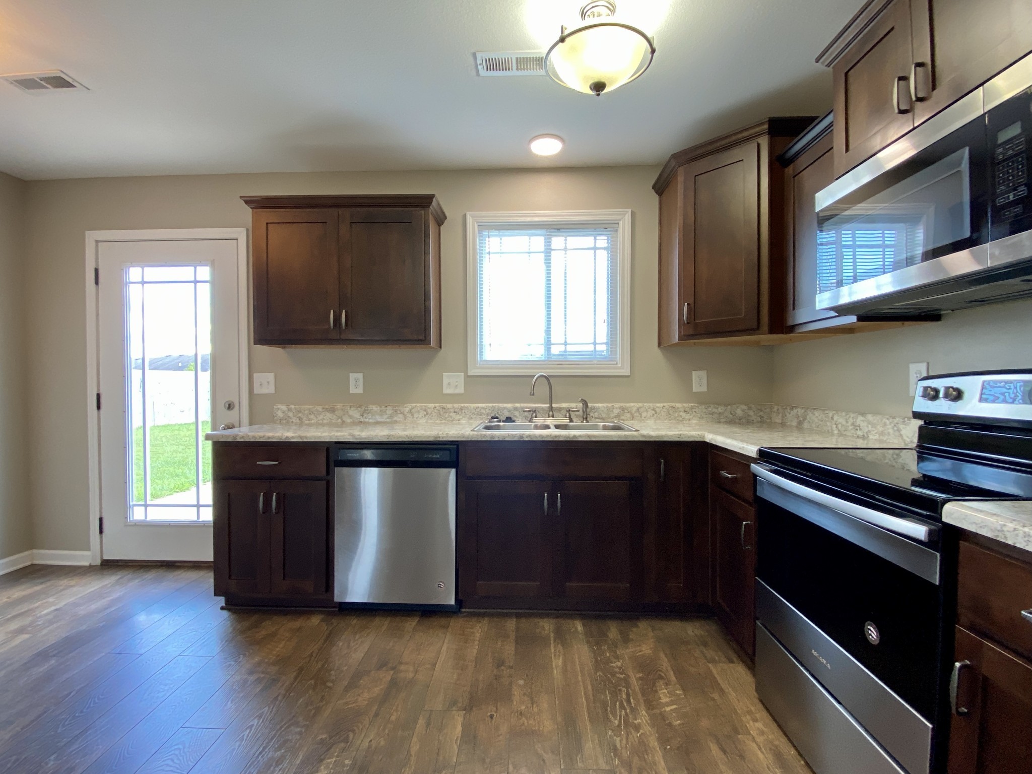 951 Hugh Hunter Road Oak Grove, KY 42262 - Photo 13 of 35 a kitchen with granite countertop wooden cabinets stainless steel appliances and a window