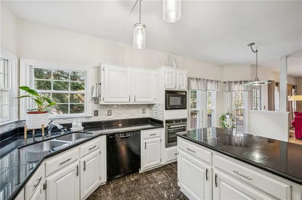 a kitchen with stainless steel appliances granite countertop a sink a stove a refrigerator a center island and cabinets