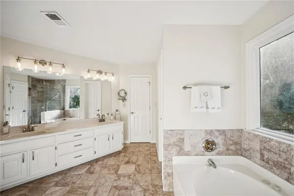 a bathroom with a bathtub sink and a mirror