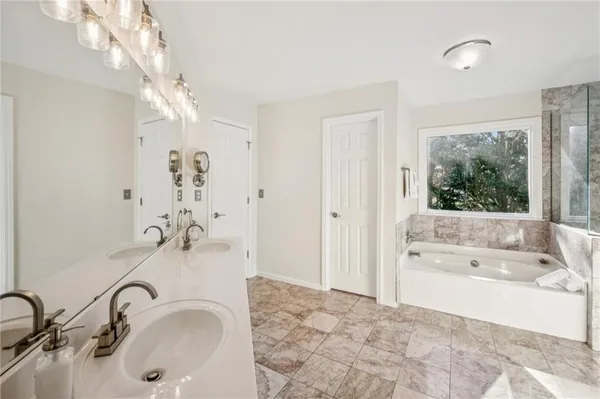 a bathroom with a tub sink and mirror