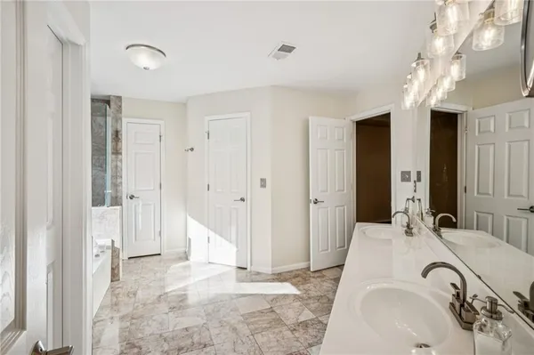 a spacious bathroom with a tub sink and shower