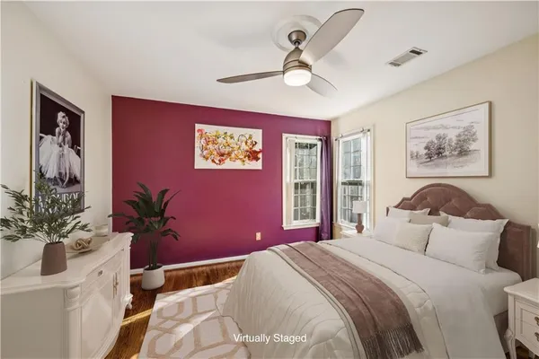 a bedroom with a large bed and a potted plant
