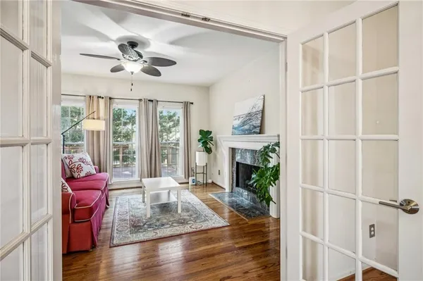 a living room with furniture a fireplace and a floor to ceiling window