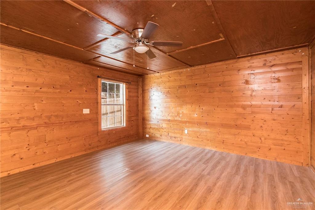 508 Patricia Street Mission, TX 78572 - Photo 11 of 24 Spacious room featuring wood-finish flooring, wood-paneled walls, and a matching wood-paneled ceiling