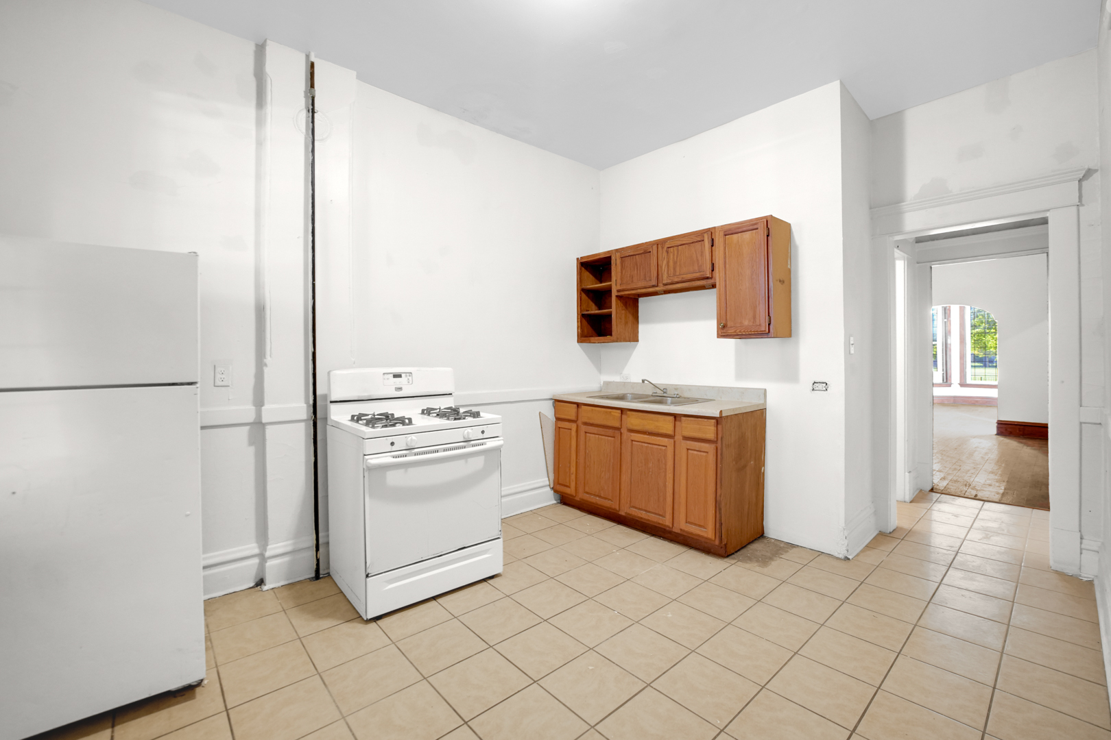 6045 South Peoria Street Chicago, IL 60621 - Photo 12 of 25 a kitchen with stainless steel appliances a stove a sink and a refrigerator