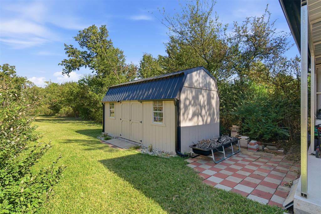 116 Cromeans Street Jacksboro, TX 76458 - Photo 26 of 32 a view of backyard with a barn and a cactus plant