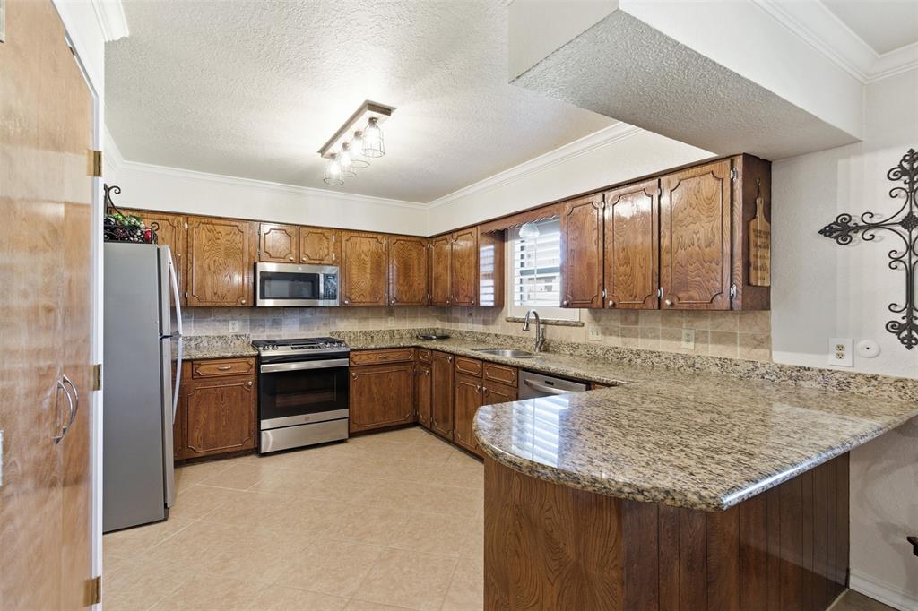 116 Cromeans Street Jacksboro, TX 76458 - Photo 7 of 32 a kitchen with stainless steel appliances granite countertop a sink stove and refrigerator