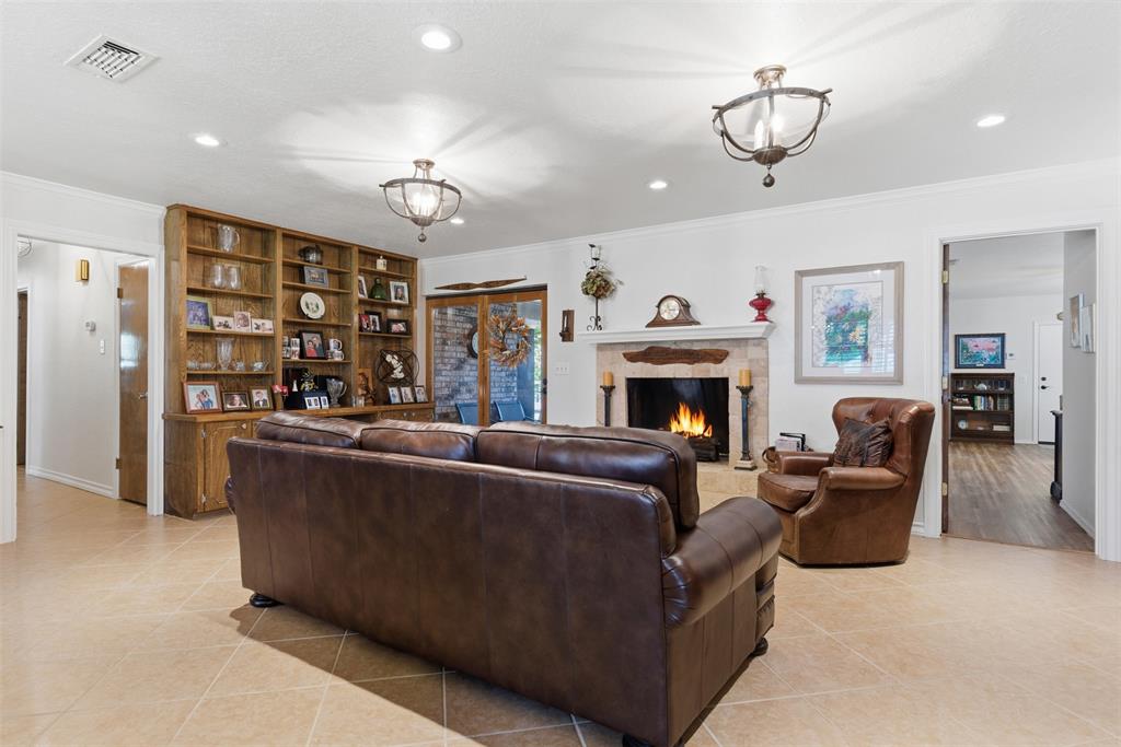 116 Cromeans Street Jacksboro, TX 76458 - Photo 10 of 32 a living room with furniture a fireplace and a chandelier