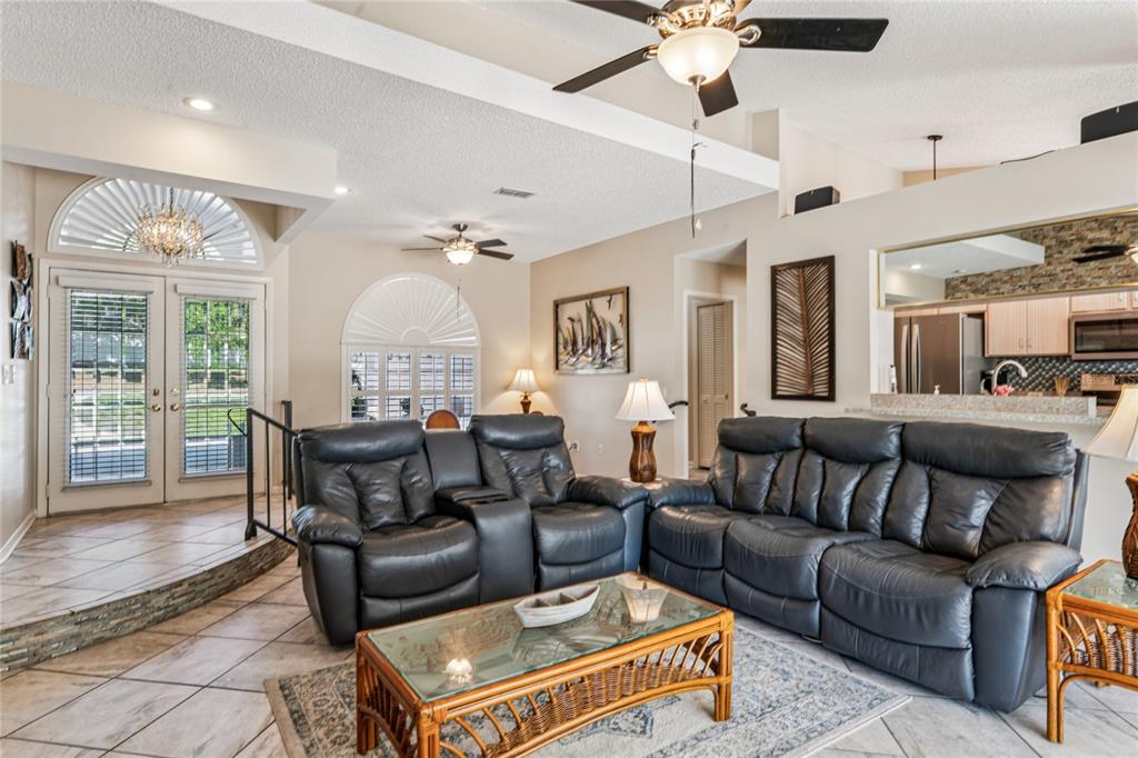 6324 India Drive Spring Hill, FL 34608 - Photo 11 of 68 a living room with furniture a chandelier and a fireplace