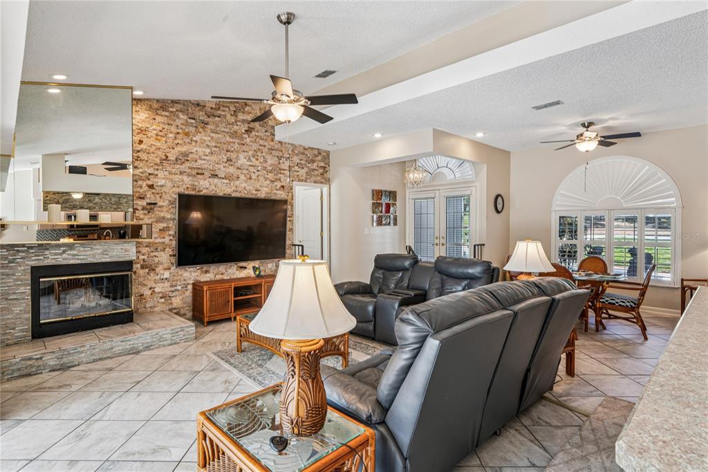 6324 India Drive Spring Hill, FL 34608 - Photo 12 of 68 a living room with furniture a fireplace and a flat screen tv