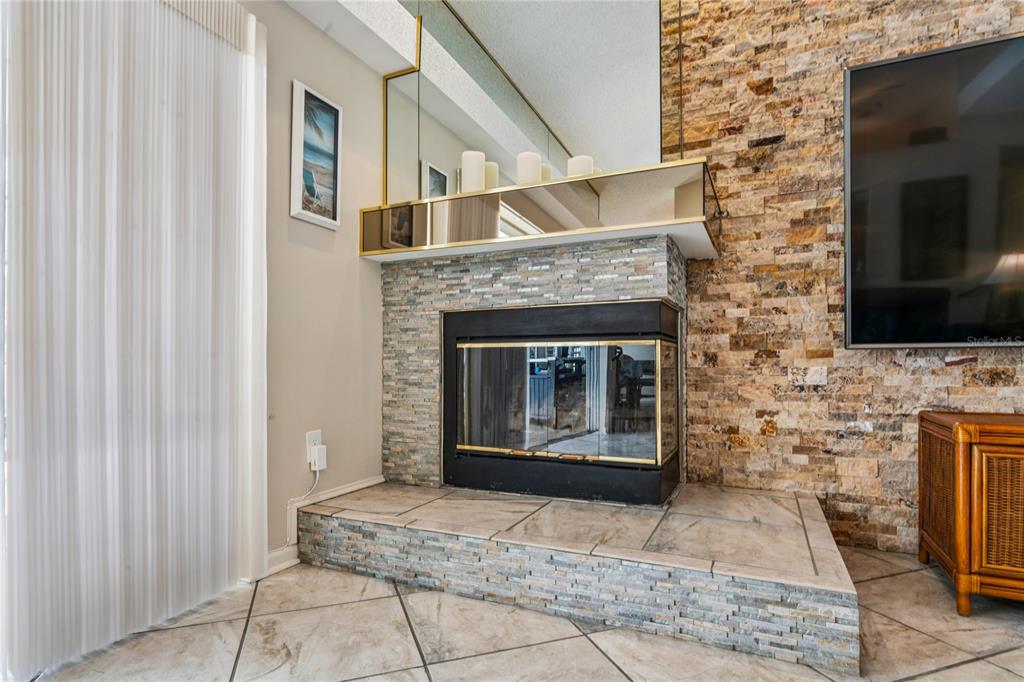 6324 India Drive Spring Hill, FL 34608 - Photo 13 of 68 a living room with a fireplace and a flat screen tv